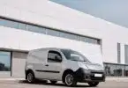 A Gray Van Parked Beside the White Concrete Building