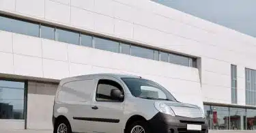 A Gray Van Parked Beside the White Concrete Building