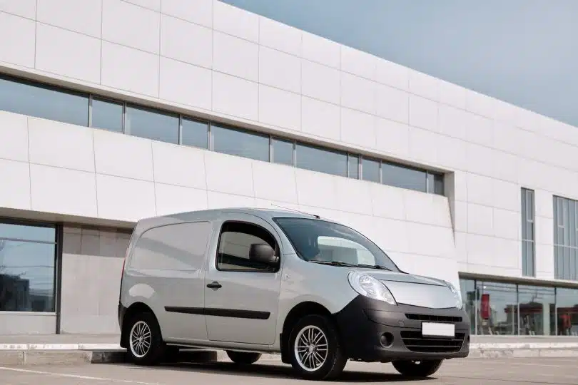 A Gray Van Parked Beside the White Concrete Building