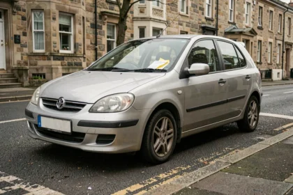 Voiture en stationnement sans assurance avec un avis de contravention sous l'essuie-glace sur une rue résidentielle