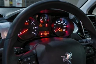 Voyants rouges allumés sur le tableau de bord d'une Peugeot 208, signalant une alerte moteur et pression d'huile